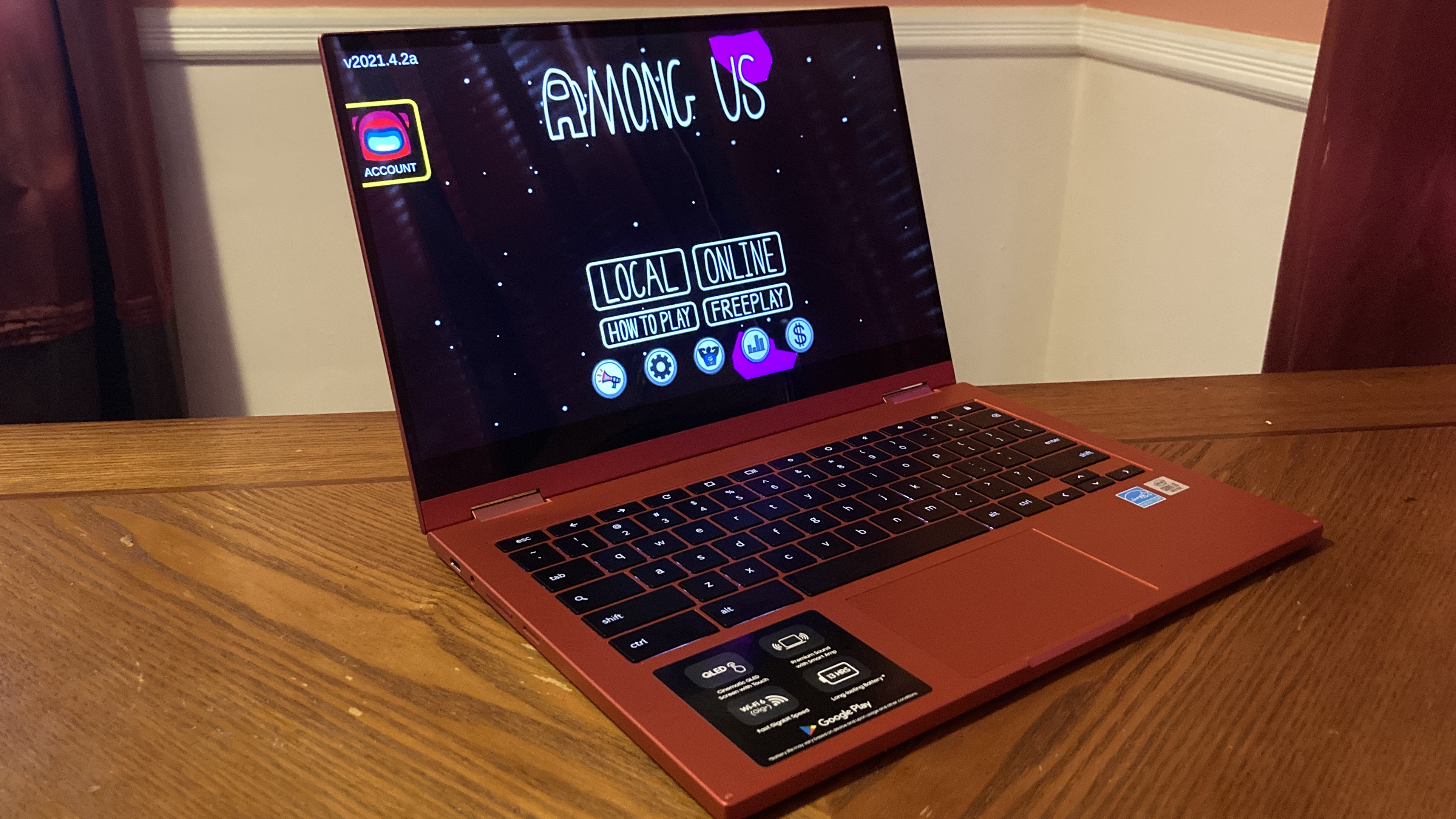 Chromebook قرمز سامسونگ روی میز چوبی با صفحه شروع بازی در میان ایالات متحده