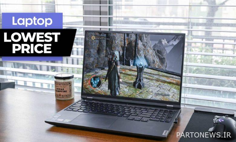 Gaming laptop on a wooden desk next to a candle
