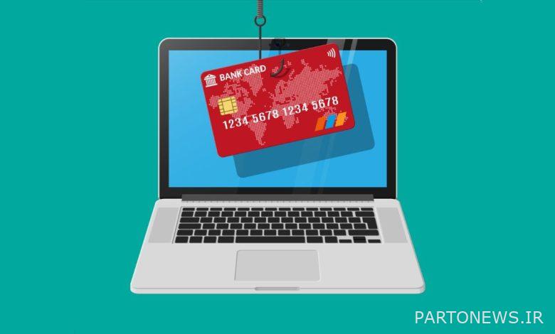 Credit card being pulled out of laptop with fishing hook