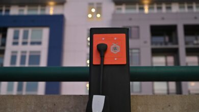 Orange Charger's Level 2 outlet sits installed in an apartment parking lot.