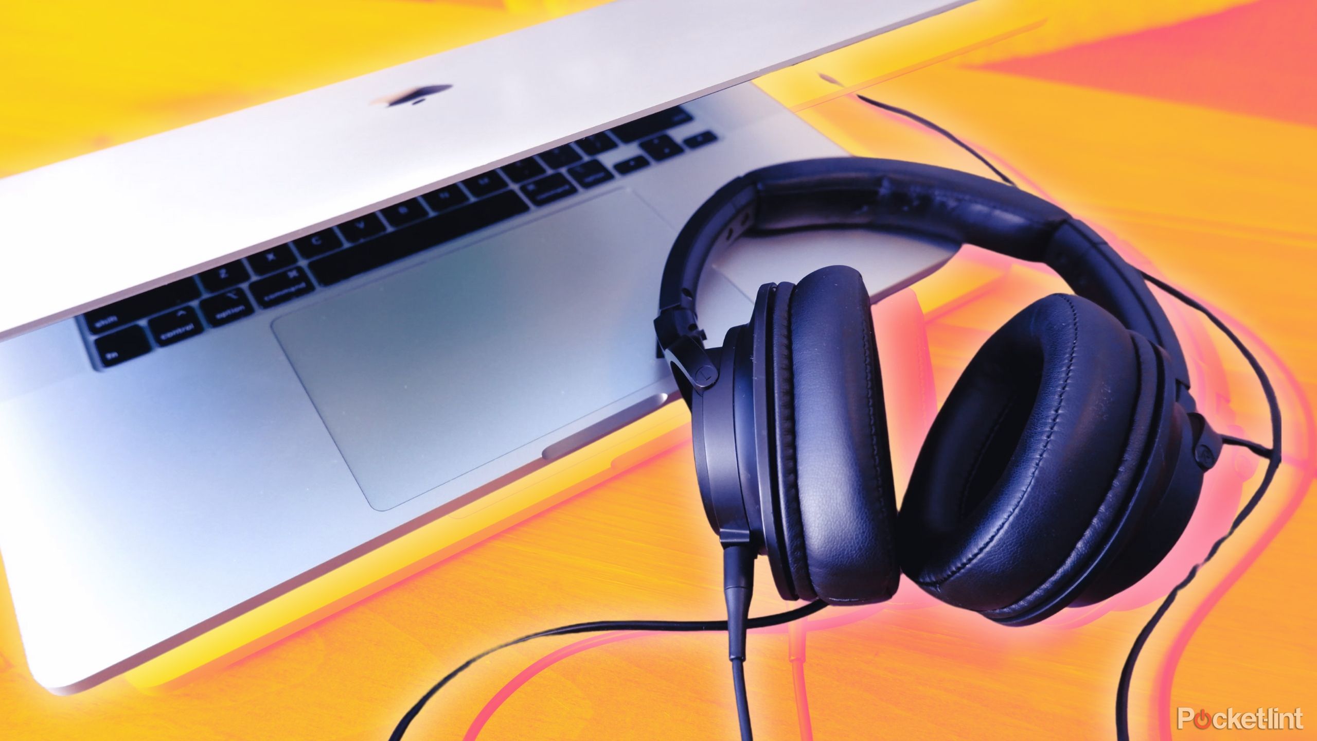 یک جفت Audio-Technica ATH-SR50 به یک Macbook Pro کمی باز وصل شده و در کنار آن قرار دارد.