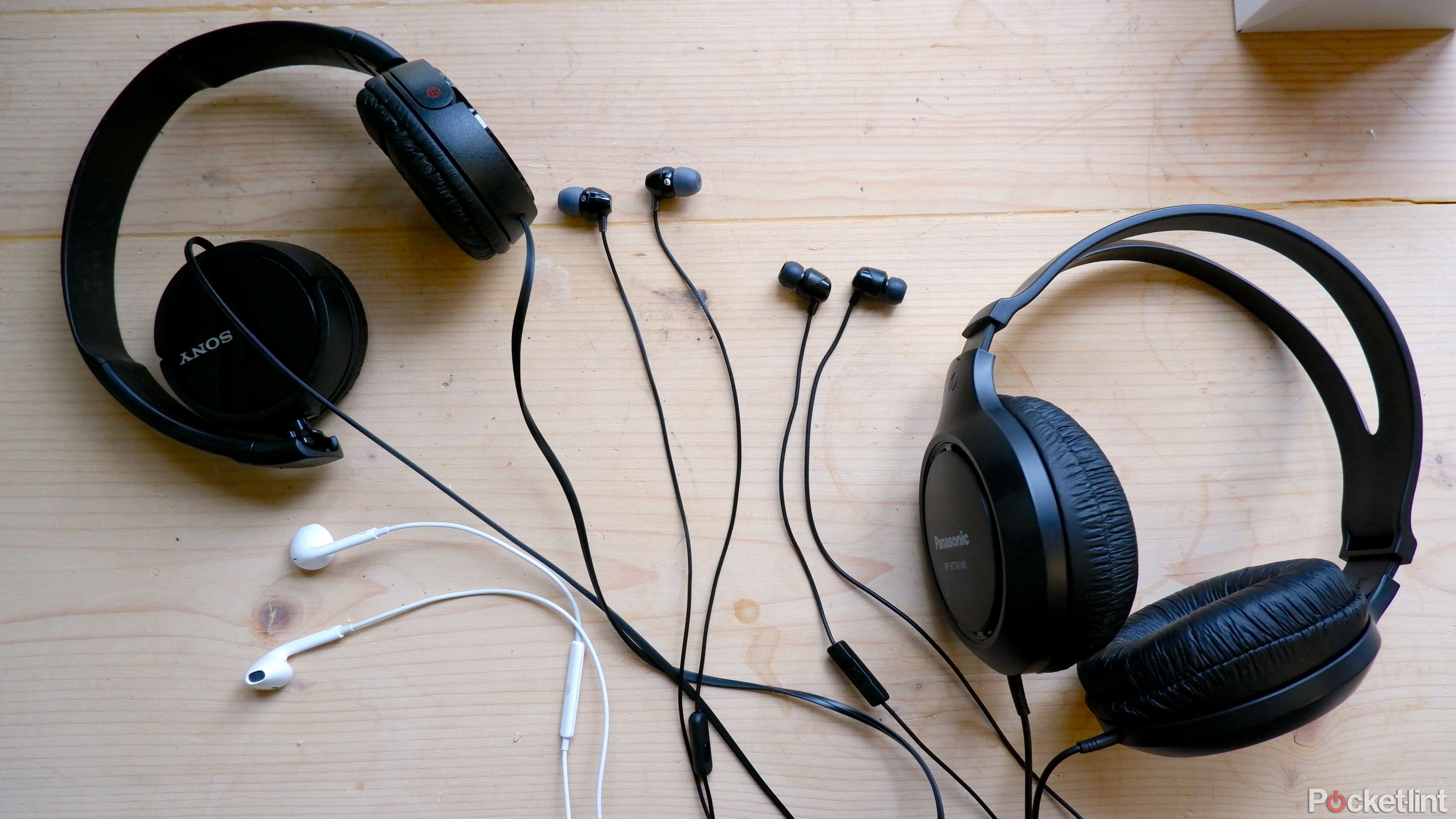 پنج هدفون سیمی پرفروش آمازون روی میز.  از چپ به راست: Sony MDR-ZX110، Apple Earpods، Sony MDR-EX15AP، Skullcandy Jib، Panasonic RP-HT161M