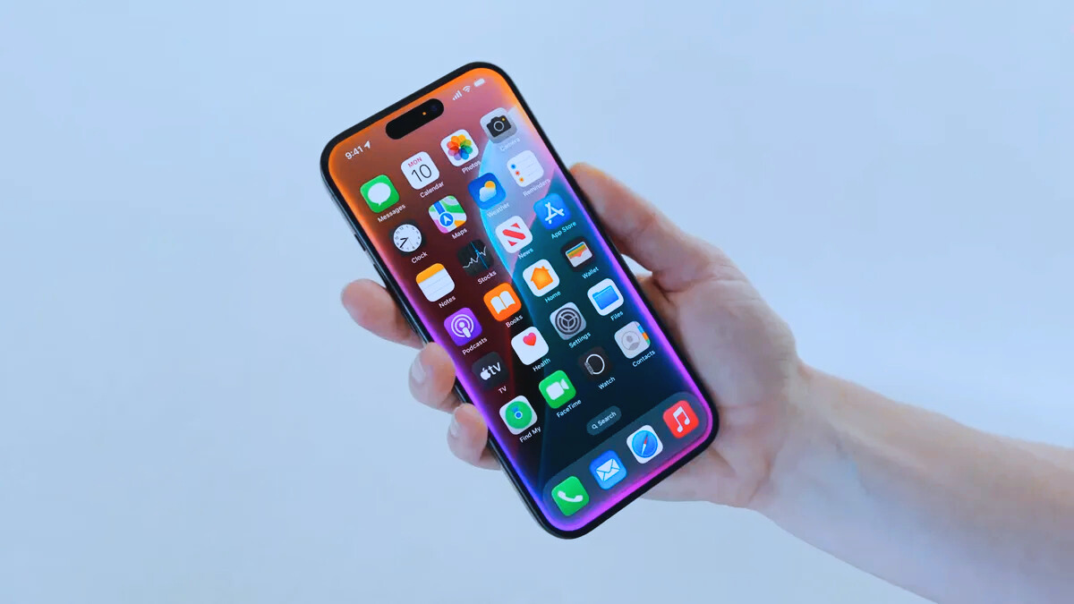 نمای نزدیک از آیفون در دست شخصی با حاشیه صفحه نمایش سیری فعال در iOS 18