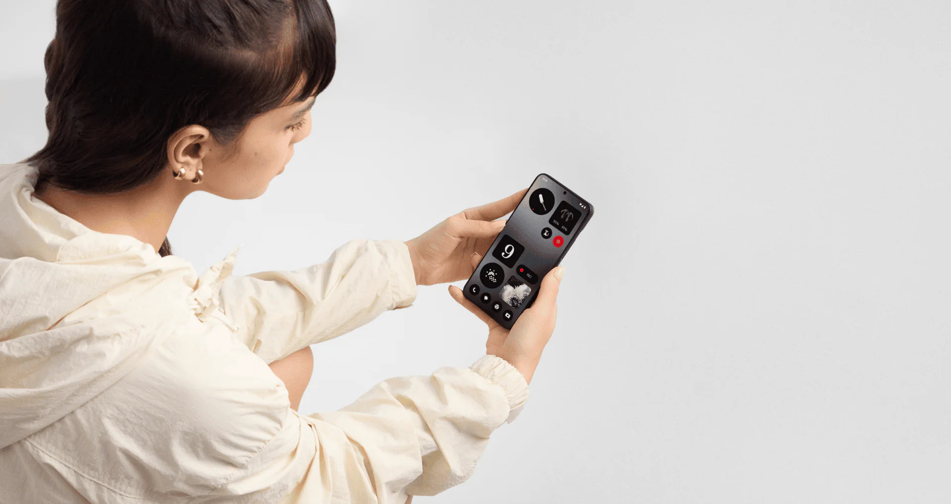 زنی که CMF را با Nothing Phone 1 در دست دارد