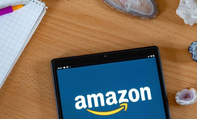 Amazon tablet on a wooden table next to a pen and notepad