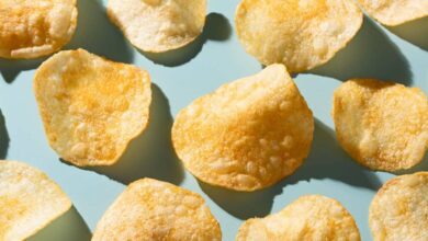 Potato chips sit against a light blue table.