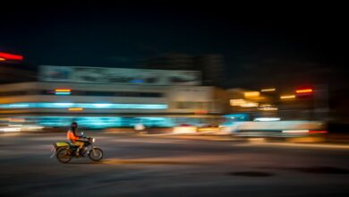 Man riding a motorbike in Kampala, Uganda, at night.