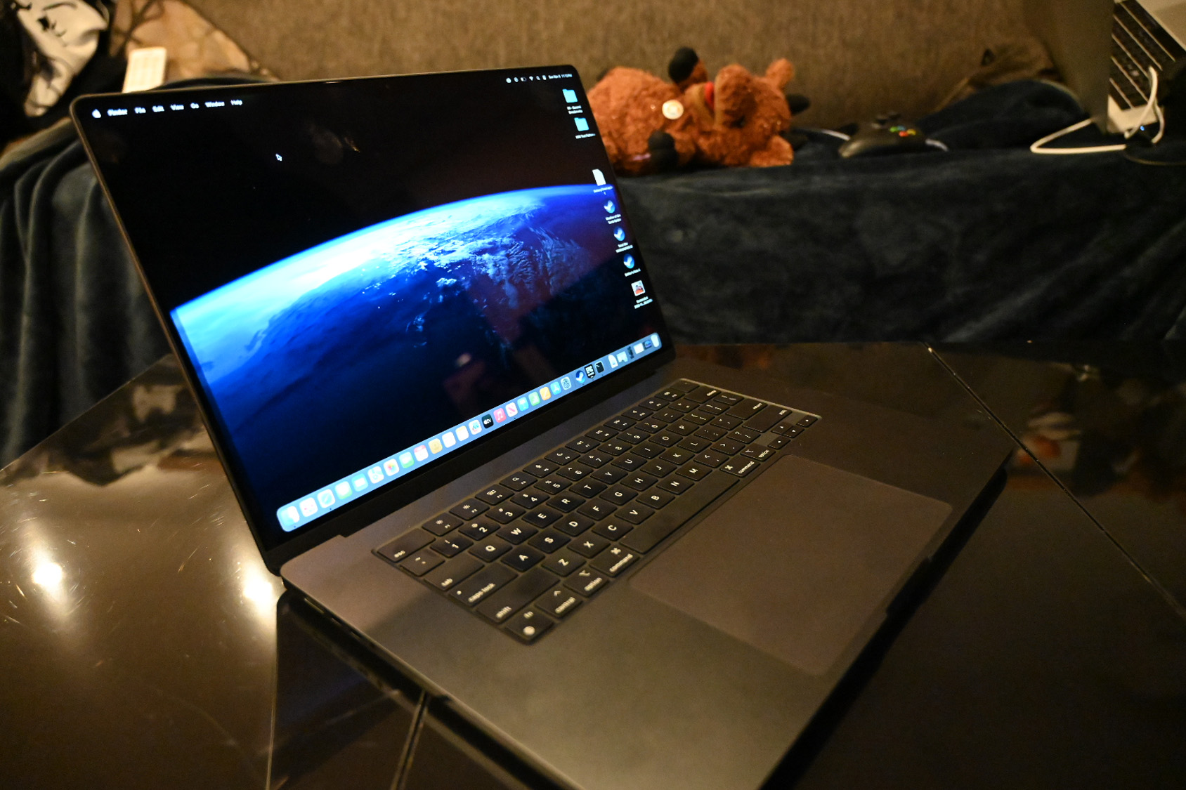 عکس زاویه دار مک بوک پرو 16 اینچی (M3 Max، 2023) باز روی میز قهوه