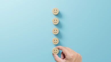 hand placing wooden block with smiley face; customer feedback from investors