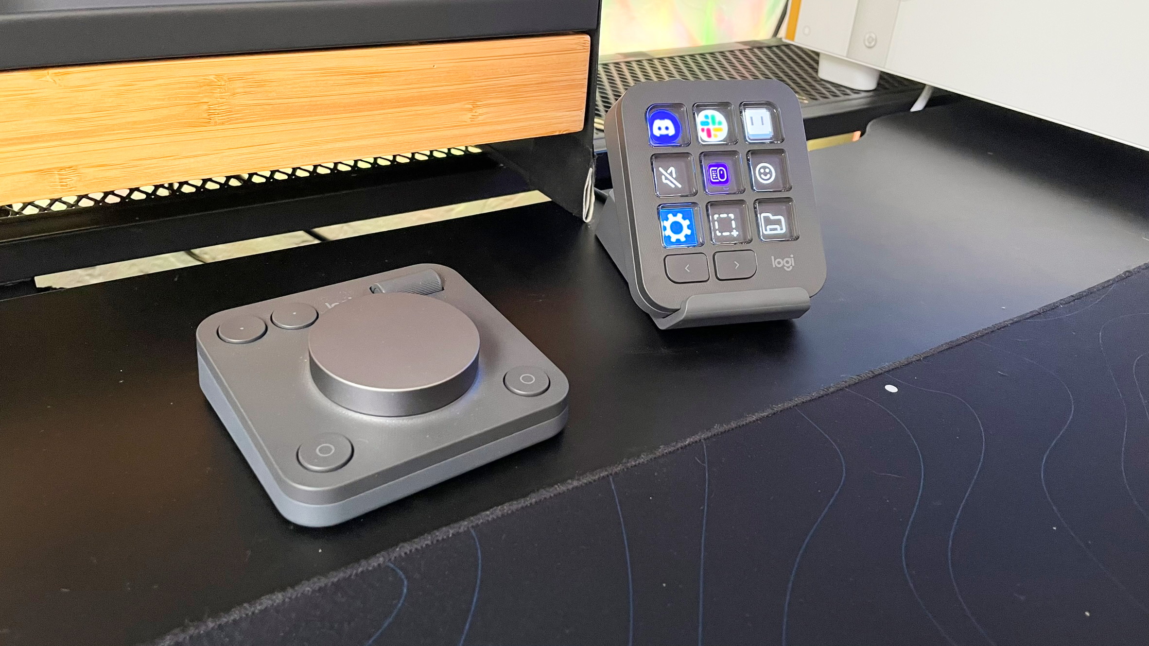 کنسول خلاق لاجیتک MX روی یک میز مشکی در مقابل یک پایه مانیتور چوبی