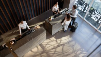 Overhead view of young business couple checking in at hotel and beautiful receptionist helping them very cheerfully