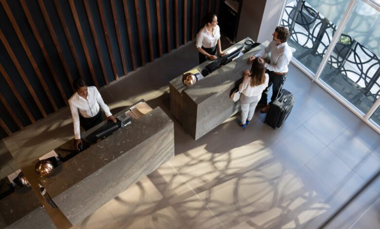 Overhead view of young business couple checking in at hotel and beautiful receptionist helping them very cheerfully