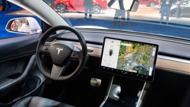 Tesla Model 3 compact full electric car interior with a large touch screen on the dashboard.