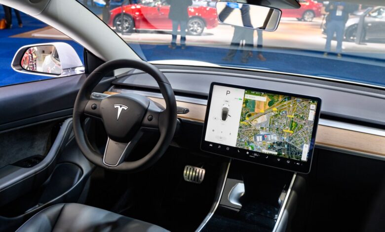Tesla Model 3 compact full electric car interior with a large touch screen on the dashboard.