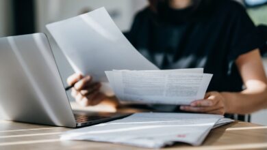 Cropped shot of young Asian woman handling personal banking and finance with laptop at home
