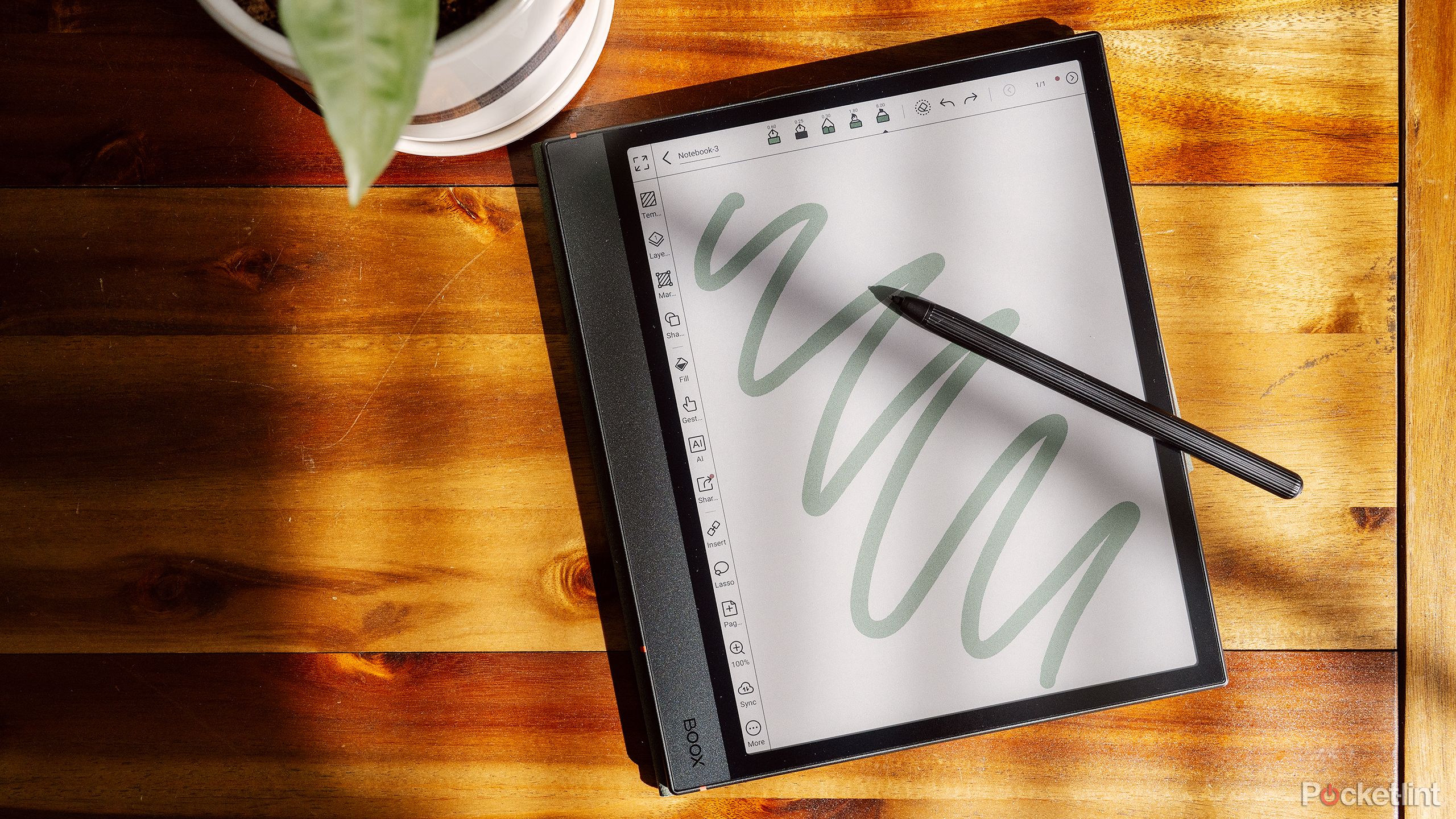 Boox Note Air4 C روی میز قهوه خوری چوبی قرار دارد. 