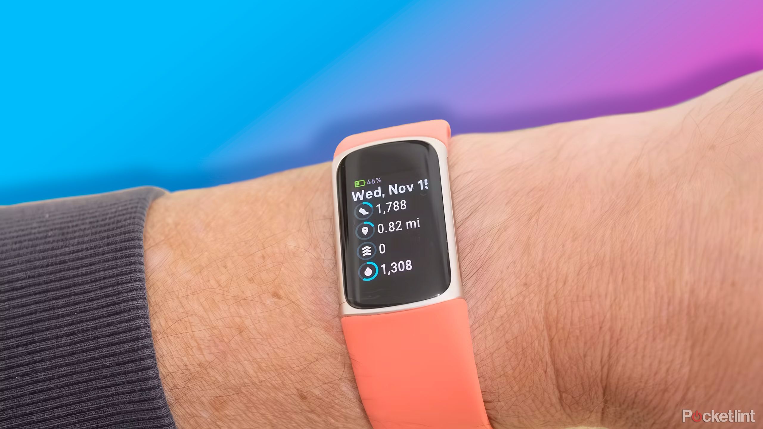 Fitbit Charge 6 روی مچ دست در مقابل شیب بنفش تا صورتی. 