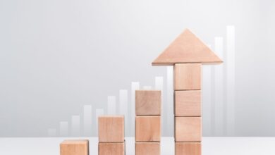 Wooden blocks stacking as an arrow up averages as a growth graph chart on white background.