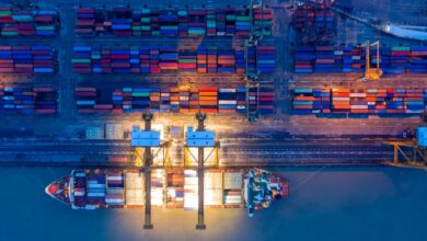 Containers yard with freight vessels loading and discharging shipments
