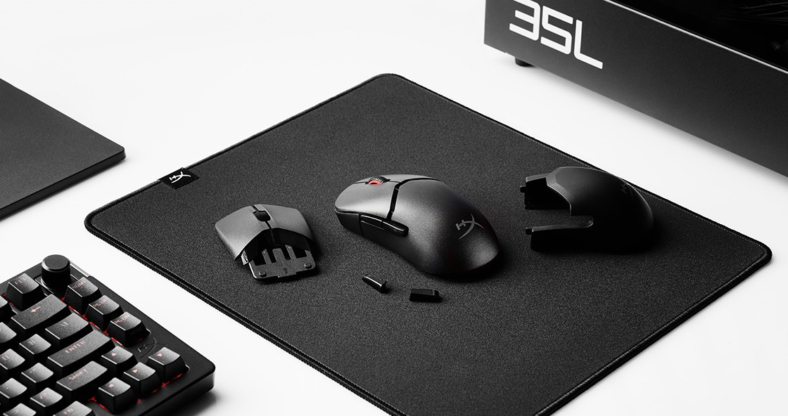 یک موس بازی HyperX Pulsefire Saga Pro روی میز با پد ماوس و قطعات یدکی