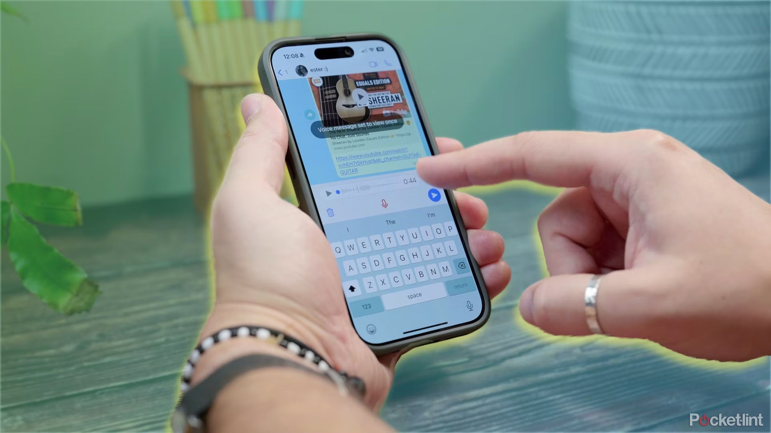 شخصی که از برنامه WhatsApp در پس زمینه رنگی استفاده می کند.