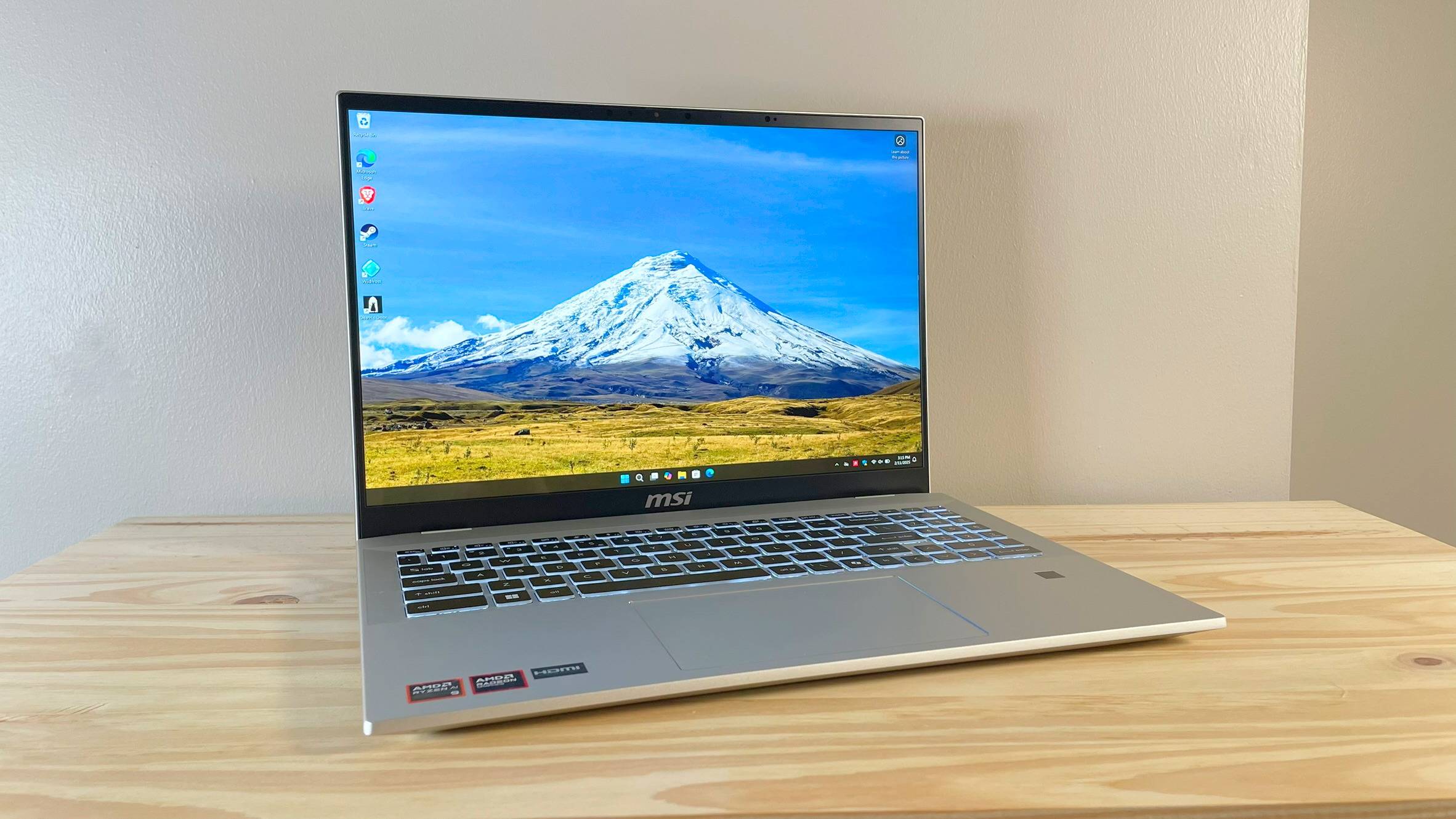 MSI Prestige A16 Ai+ با درب باز روی یک میز چوبی