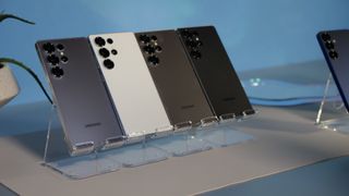 تلفن های فوق العاده Samsung Galaxy S25 در تمام رنگ های استاندارد با زاویه ای روی غرفه های شفاف.