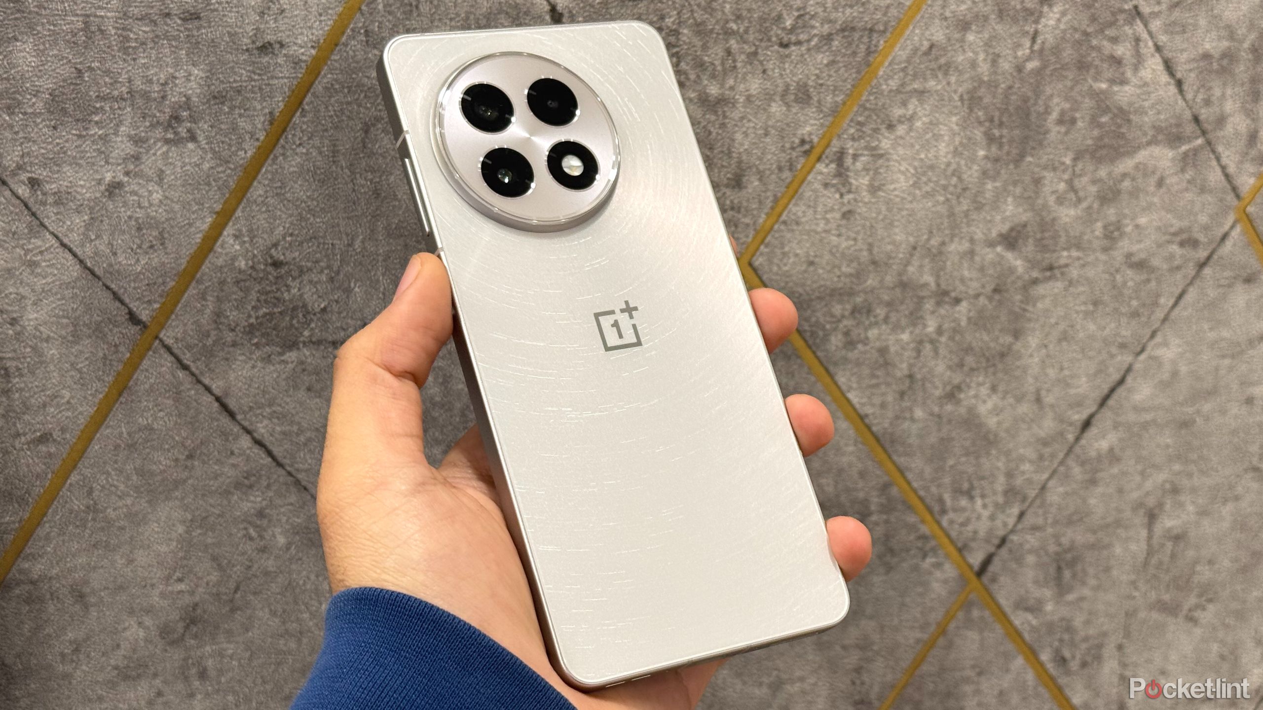 OnePlus 13r در دست ، نمایش پشت تلفن را نشان می دهد