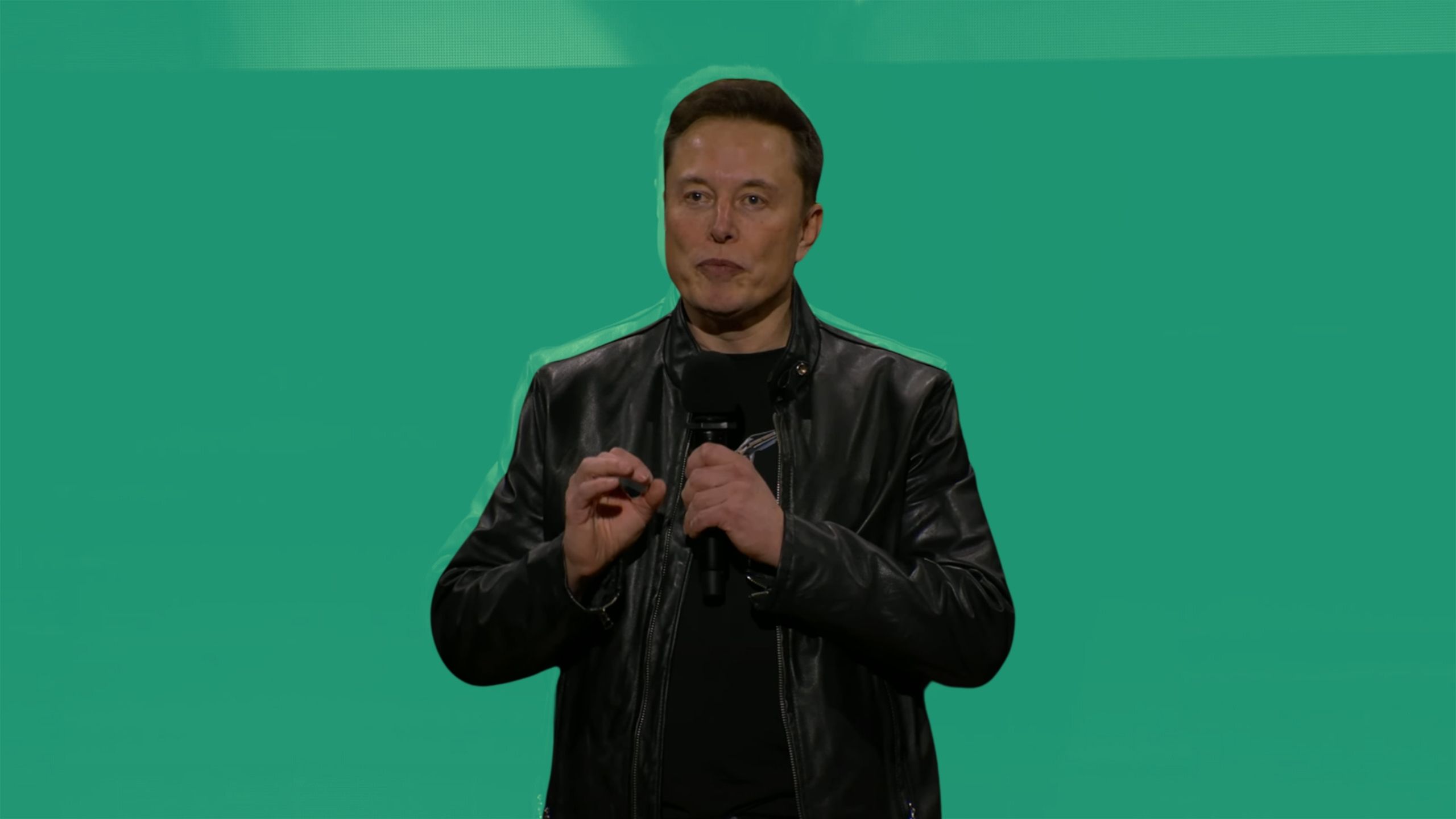 الون مسک در حال صحبت در رویداد Robot We در پس زمینه رنگی است