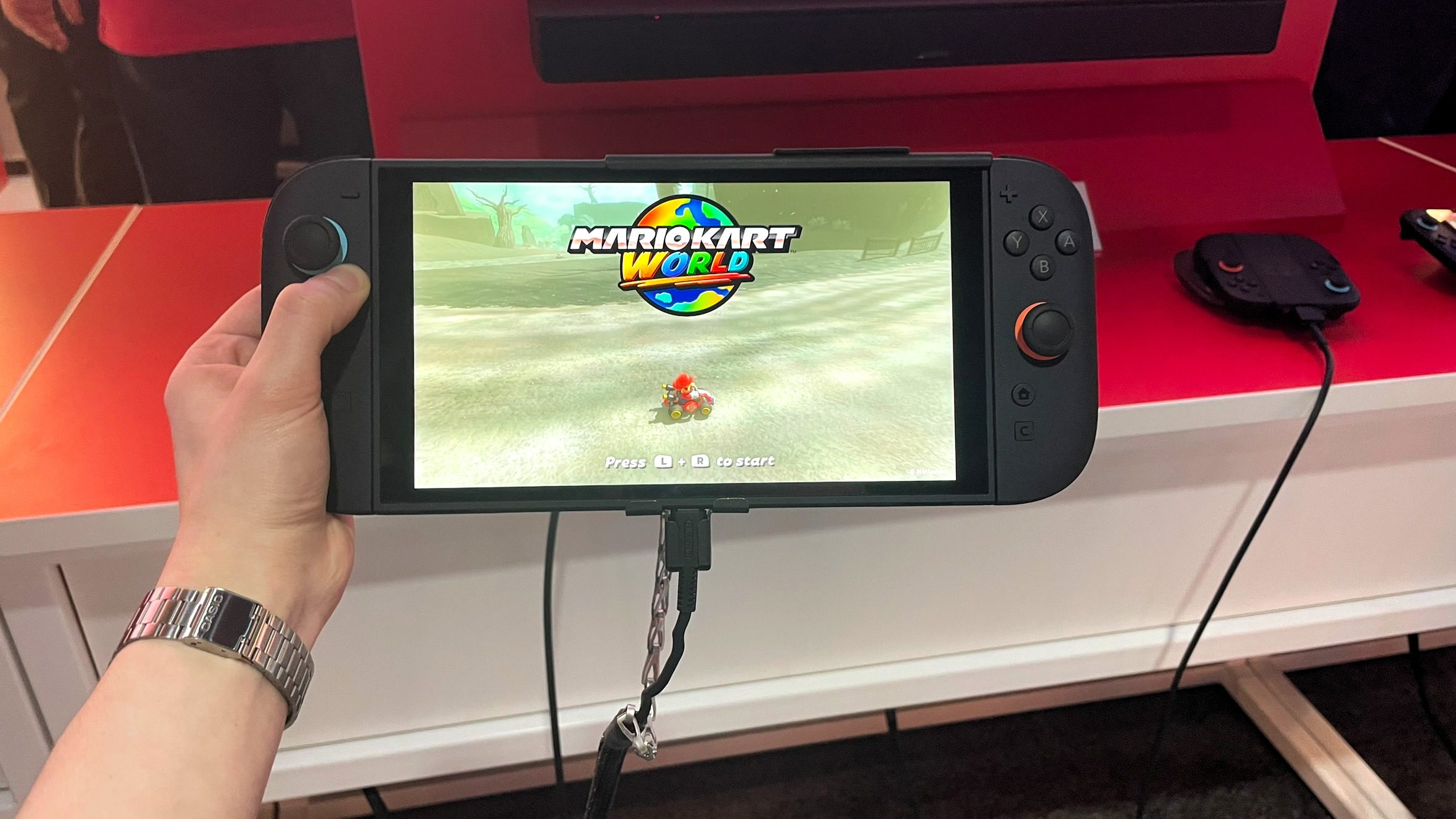 دستی که سوئیچ 2 را در حالت دستی در حین اجرای Mario Kart World در رویداد پیش نمایش Switch 2 NYC در 4 آوریل 2025 برگزار می کند