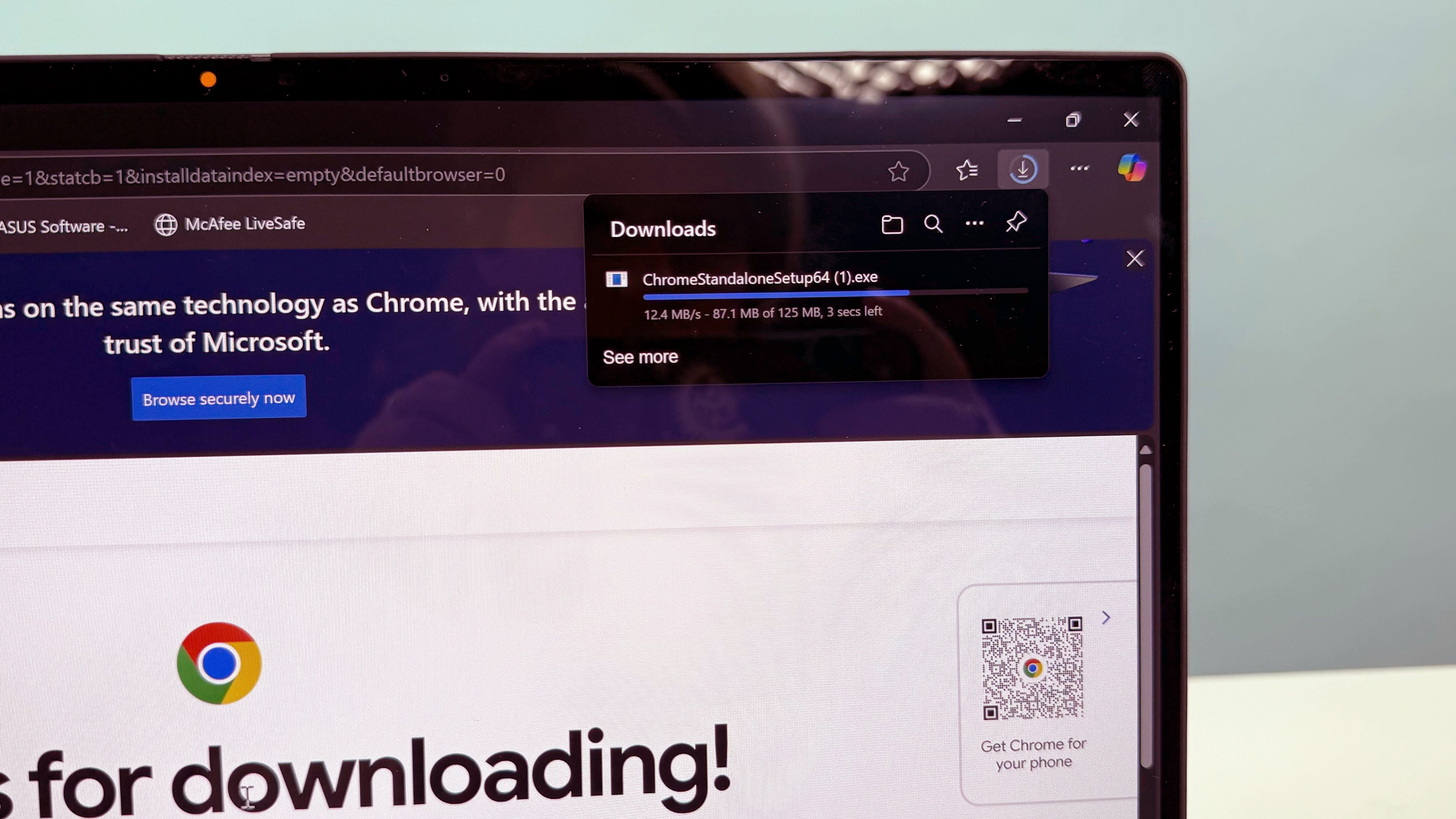 Closeup از نصب کننده آفلاین Google Chrome قابل اجرا در Asus VivoBook 16 Flip ، روی یک میز سفید در برابر پس زمینه آبی.
