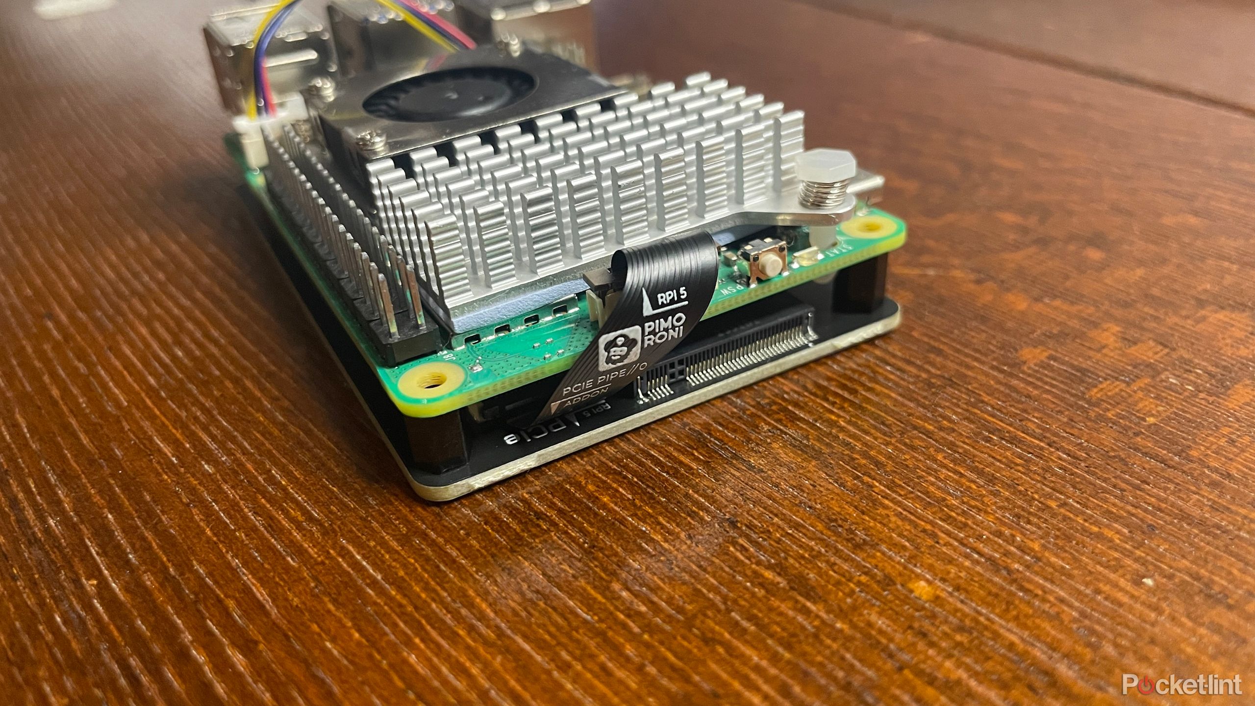 نزدیک روی کابل روبان متصل به پایه Pimoroni NVME و Rapberry Pi 5