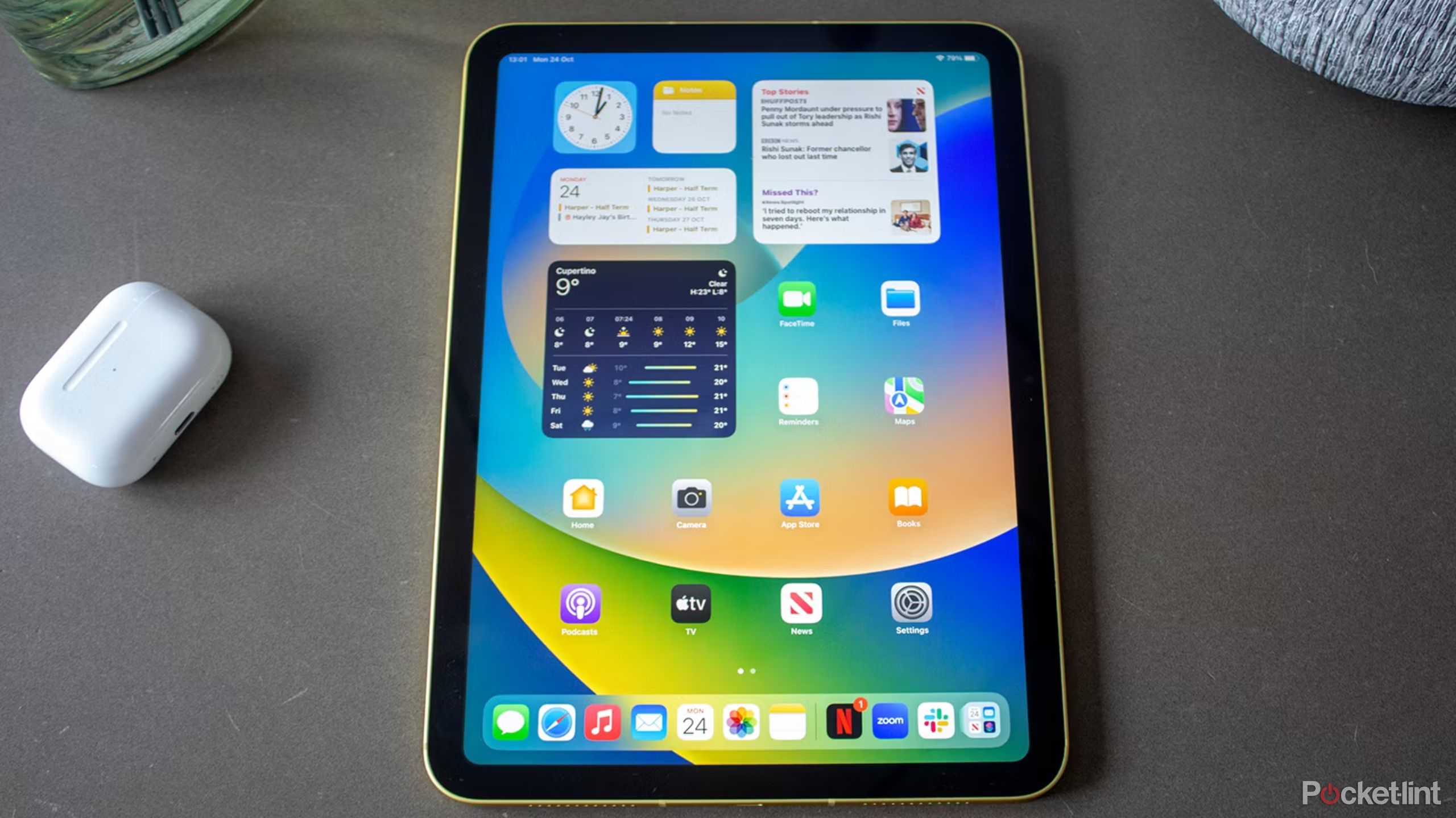 یک iPad ژنرال دهم روی میز کنار AirPods.