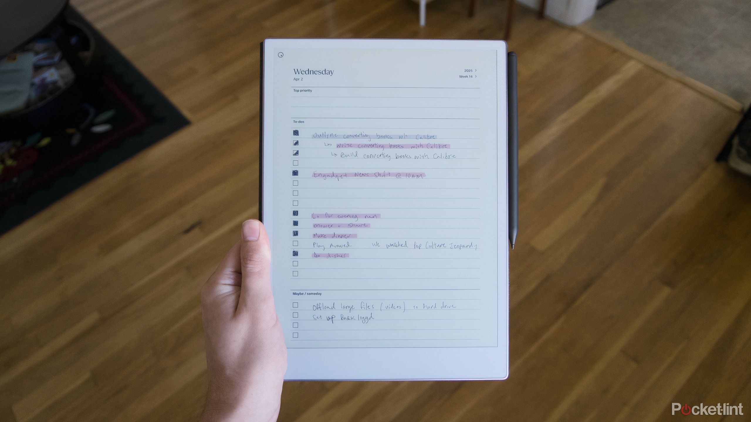 دستی که دارای یک کاغذ کاغذی قابل توجه با الگوی لیست کارهای انجام شده است.