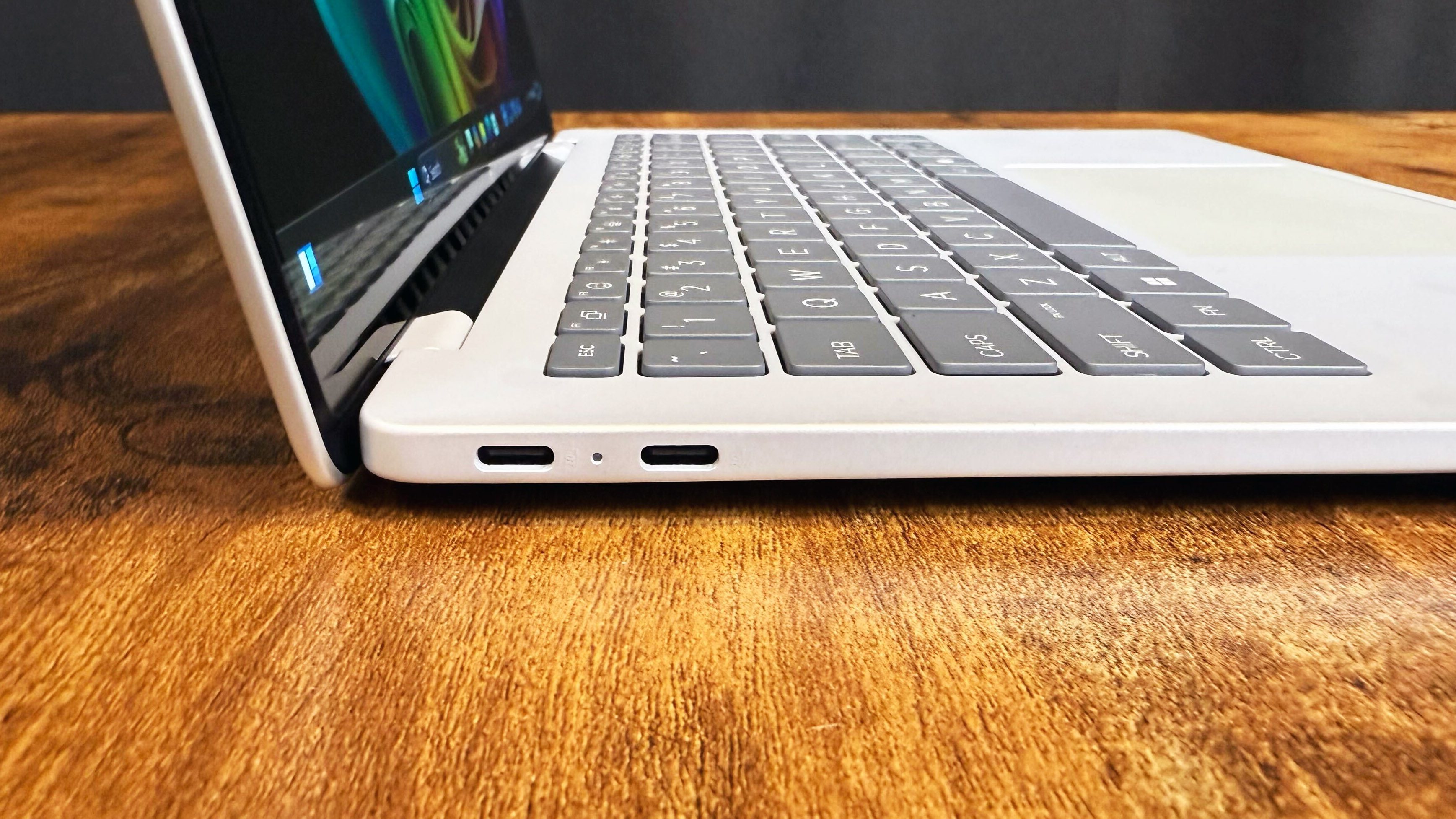 HP Omnibook 5 14 AI PC روی یک میز چوبی در برابر پس زمینه سیاه.