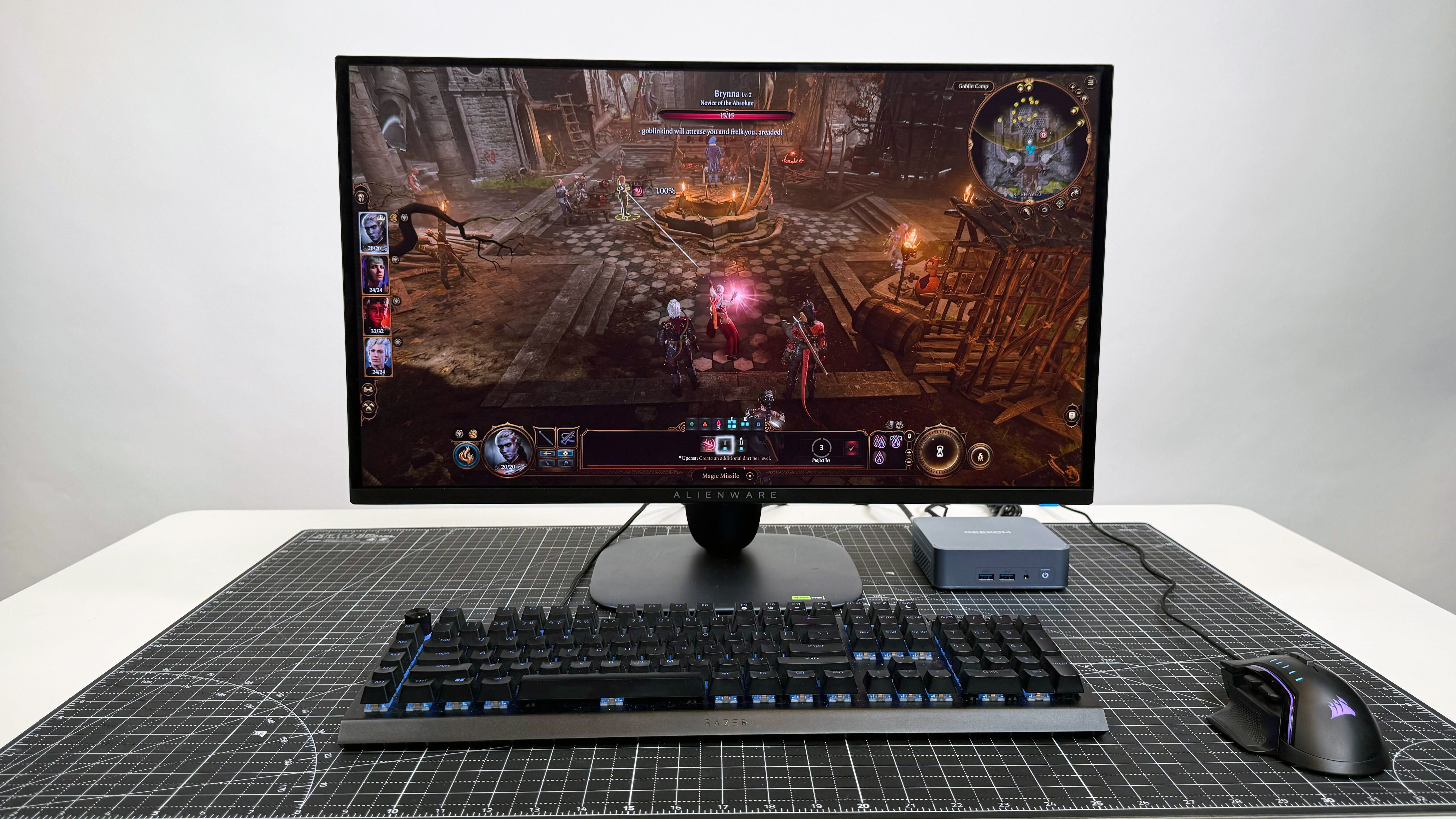 Geekom Ax8 Pro Ai Mini PC با یک مانیتور ، صفحه کلید و ماوس بر روی یک تشک سیاه در برابر پس زمینه سفید تنظیم شده است.