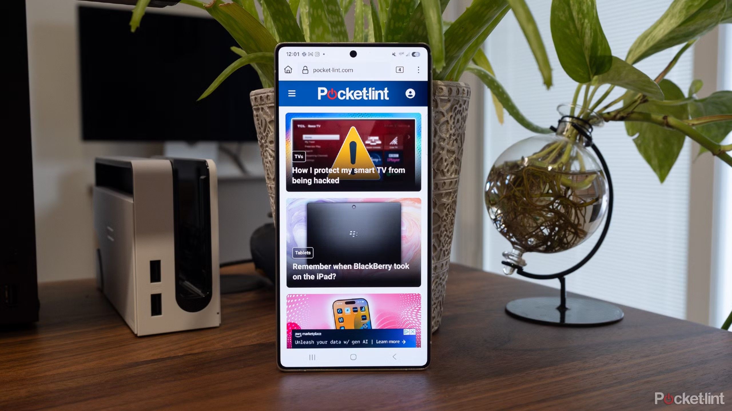Galaxy S25 Ultra با وب سایت Pocket-Lint روی یک میز با گیاهان کشیده شد. 