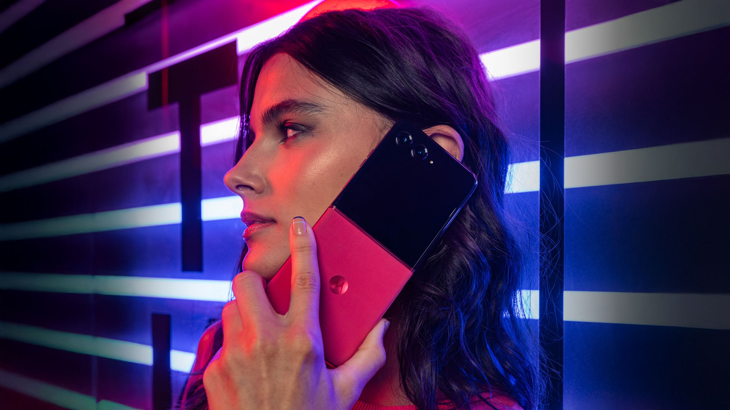 Motorola Razr+ دست در روشنایی قرمز تیره. 