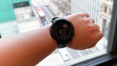 Garmin Instinct 2 Solar on left wrist, in front of a window overlooking Bryant Park in New York City.