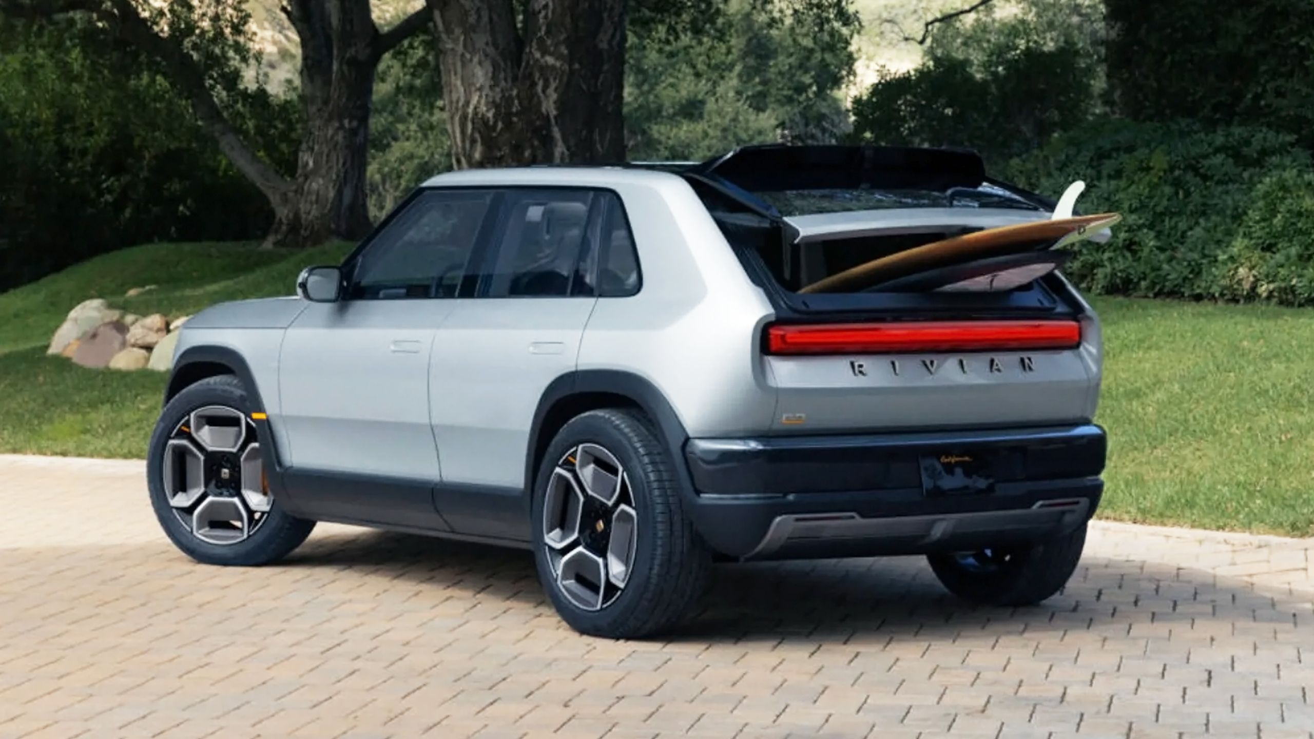 R3 Rivian با تخته های گشت و گذار از صندوق عقب آن بیرون می آید.