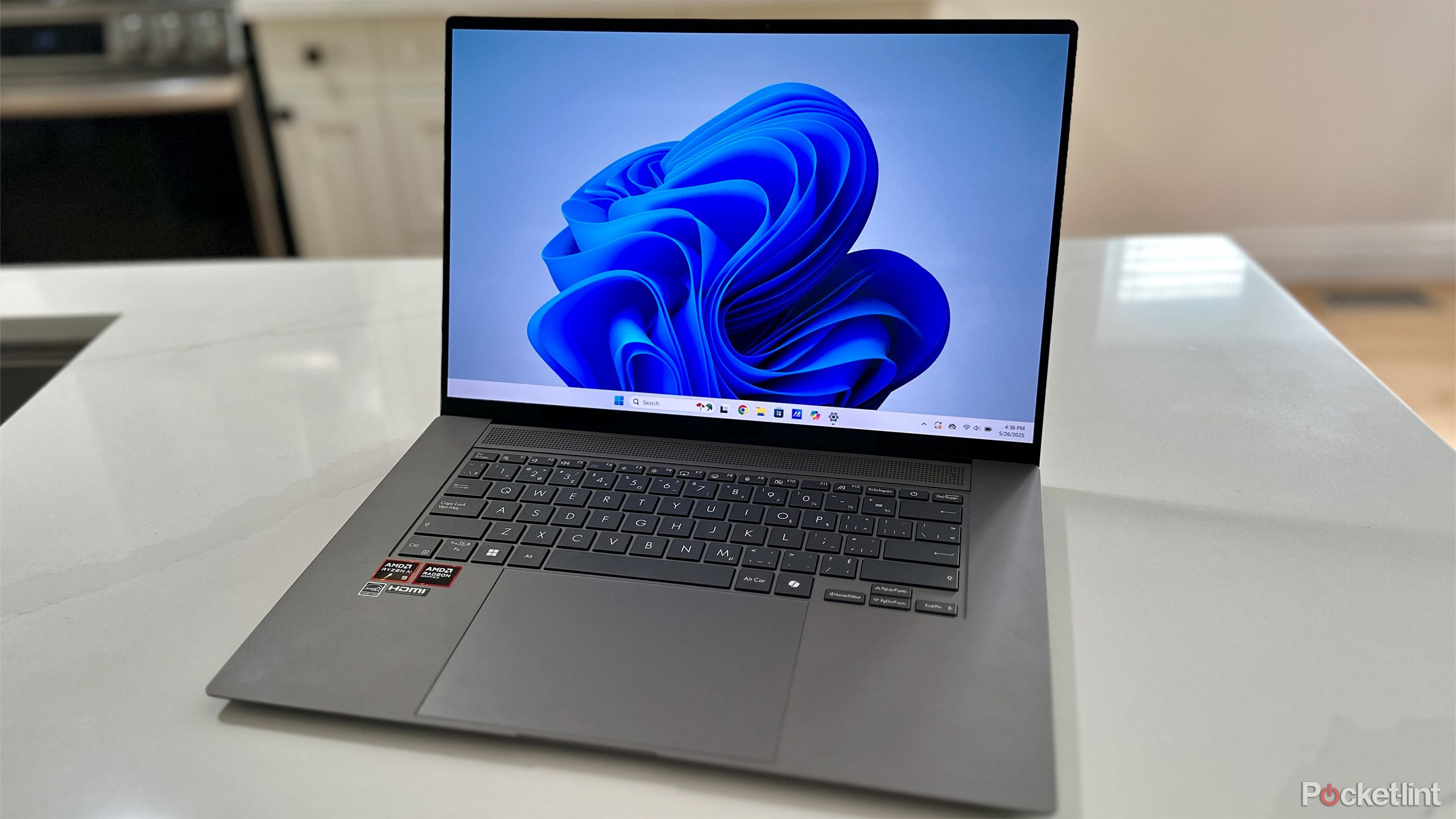 ASUS Windows 11 PC در پیشخوان آشپزخانه سفید.