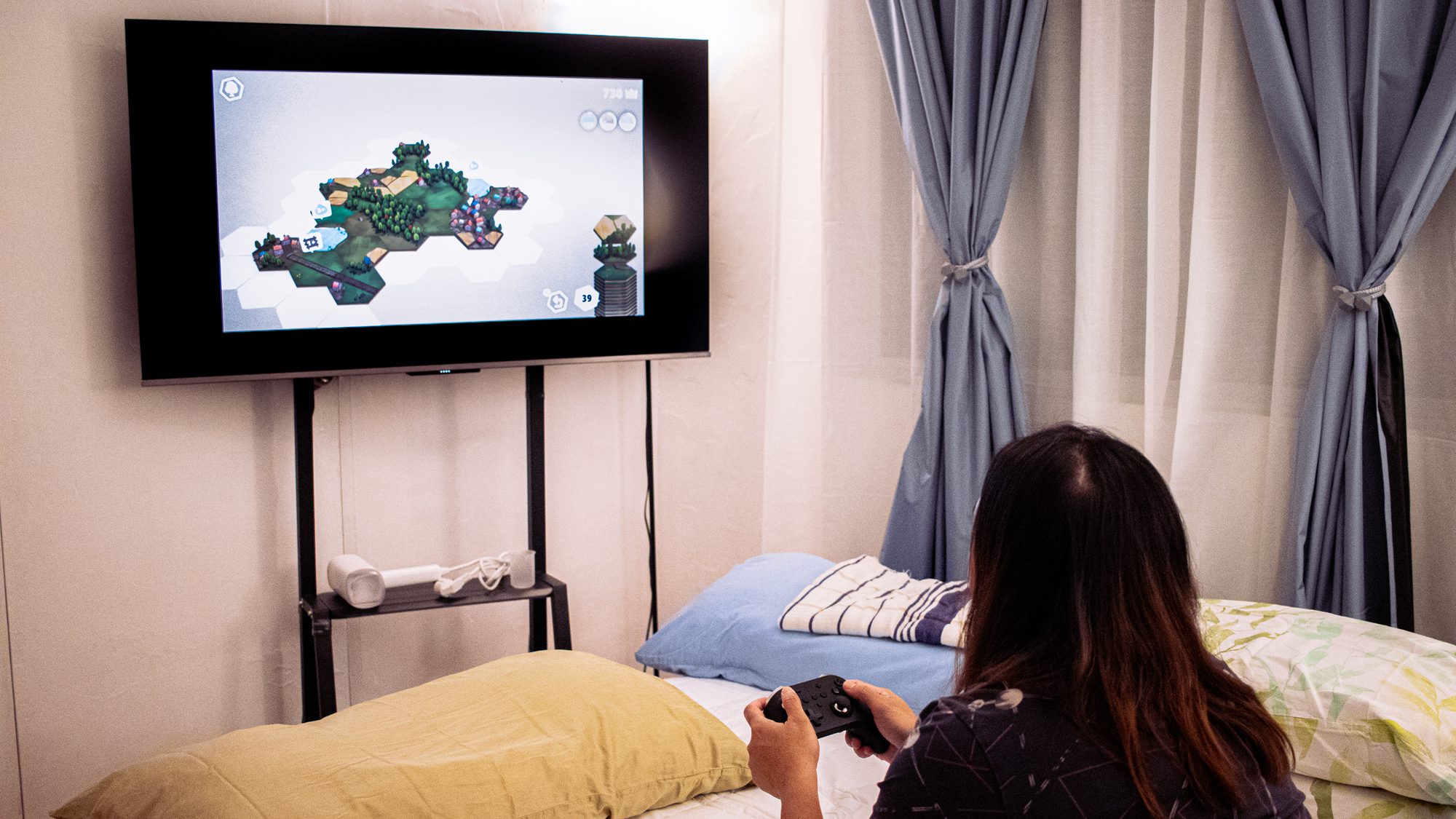 زنی که یک بازی ویدیویی در تلویزیون با یک کنترلر بازی می کند