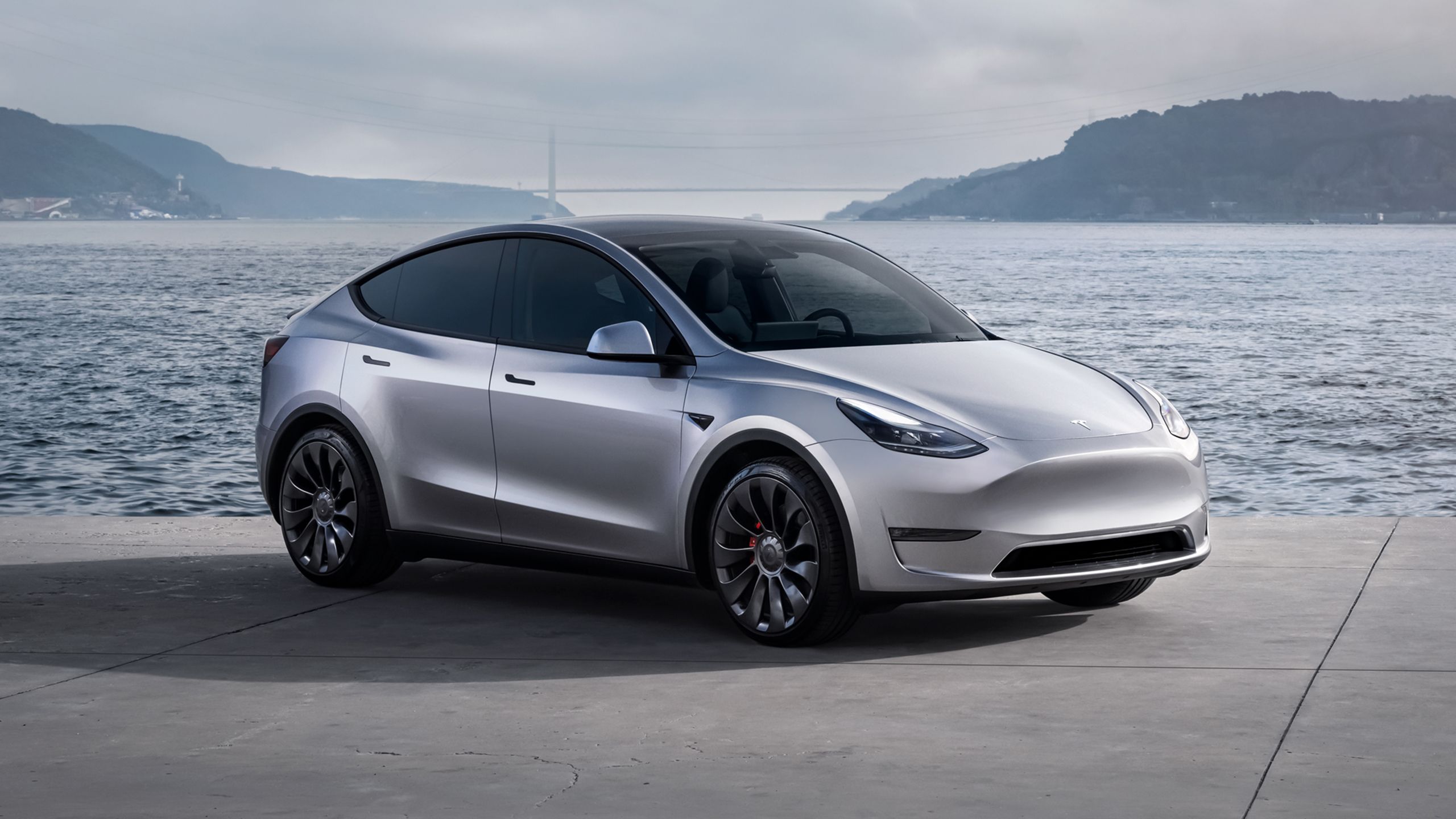 Tesla Model y در مقابل یک خلیج در یک روز ابری.