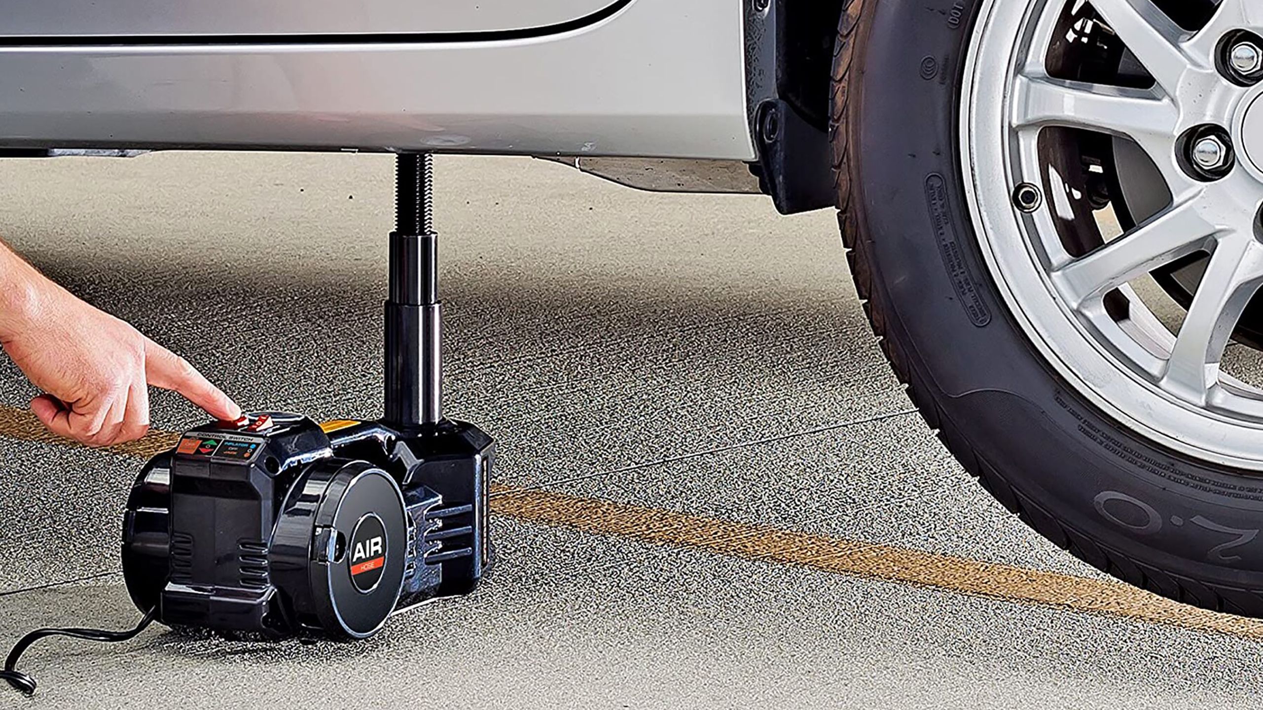 یک جک هوای برقی در زیر وسیله نقلیه.