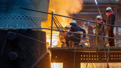Steel workers releasing molten metal into a mould.