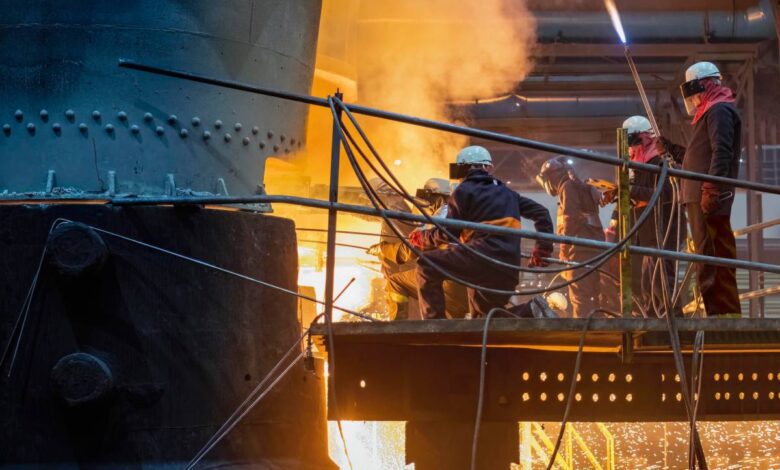 Steel workers releasing molten metal into a mould.