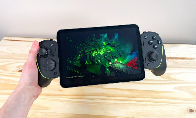 A hand holding up the iPad Mini 7 connected to the Razer Kishi Ultra controller running Hades