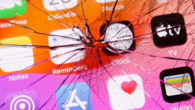 App icons displayed on a phone screen are seen through the broken glass in this illustration photo.