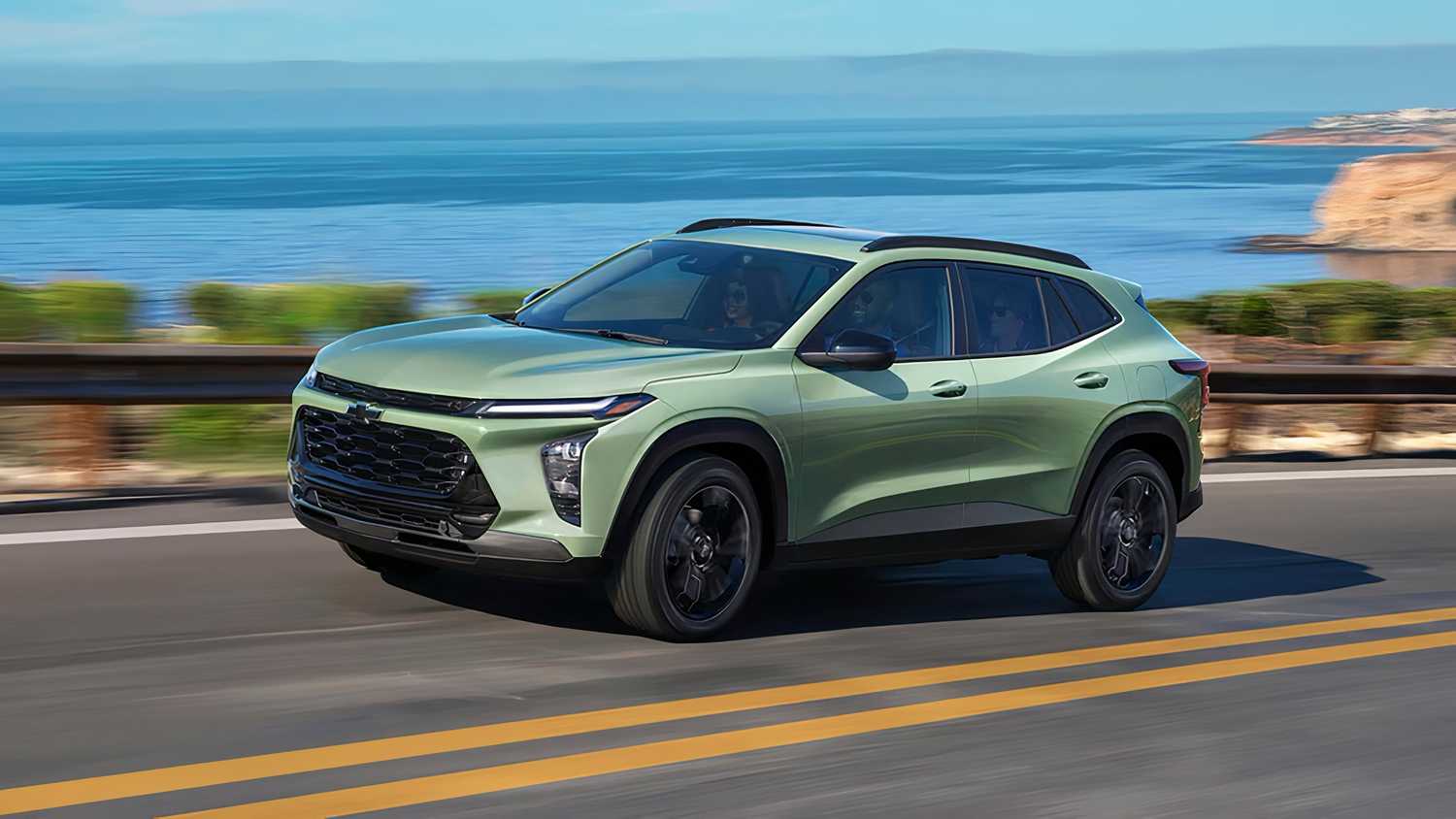 یک Chevy سبز در کنار آب رانندگی می کند. 