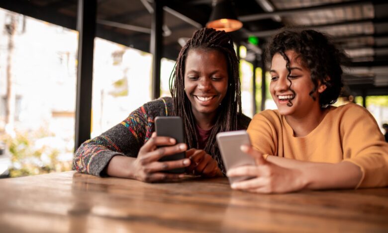 Photo of two friends sending money to each other through a digital wallet on their smartphones
